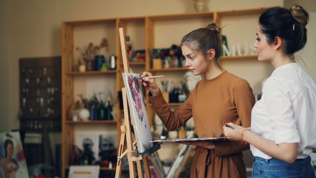 Dve žene slikaju sliku u umetničkom studiju