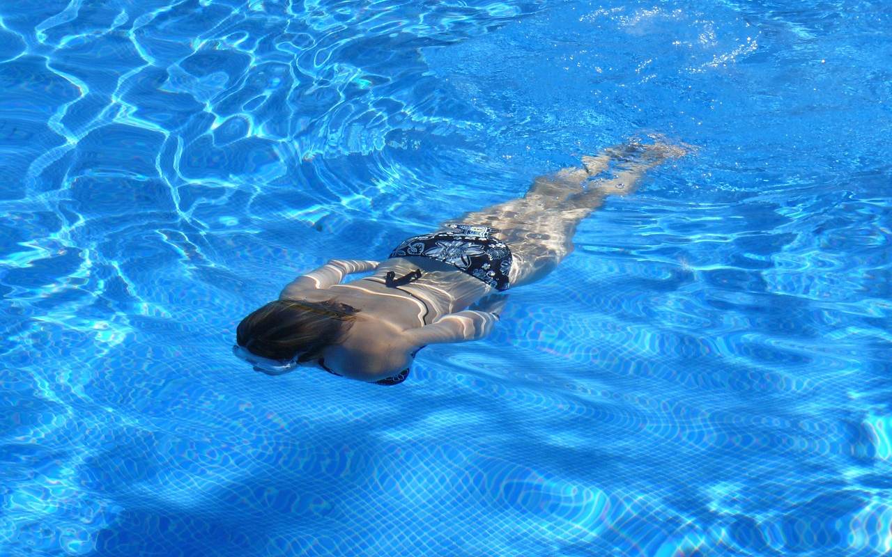 Žena pliva u bazenu.